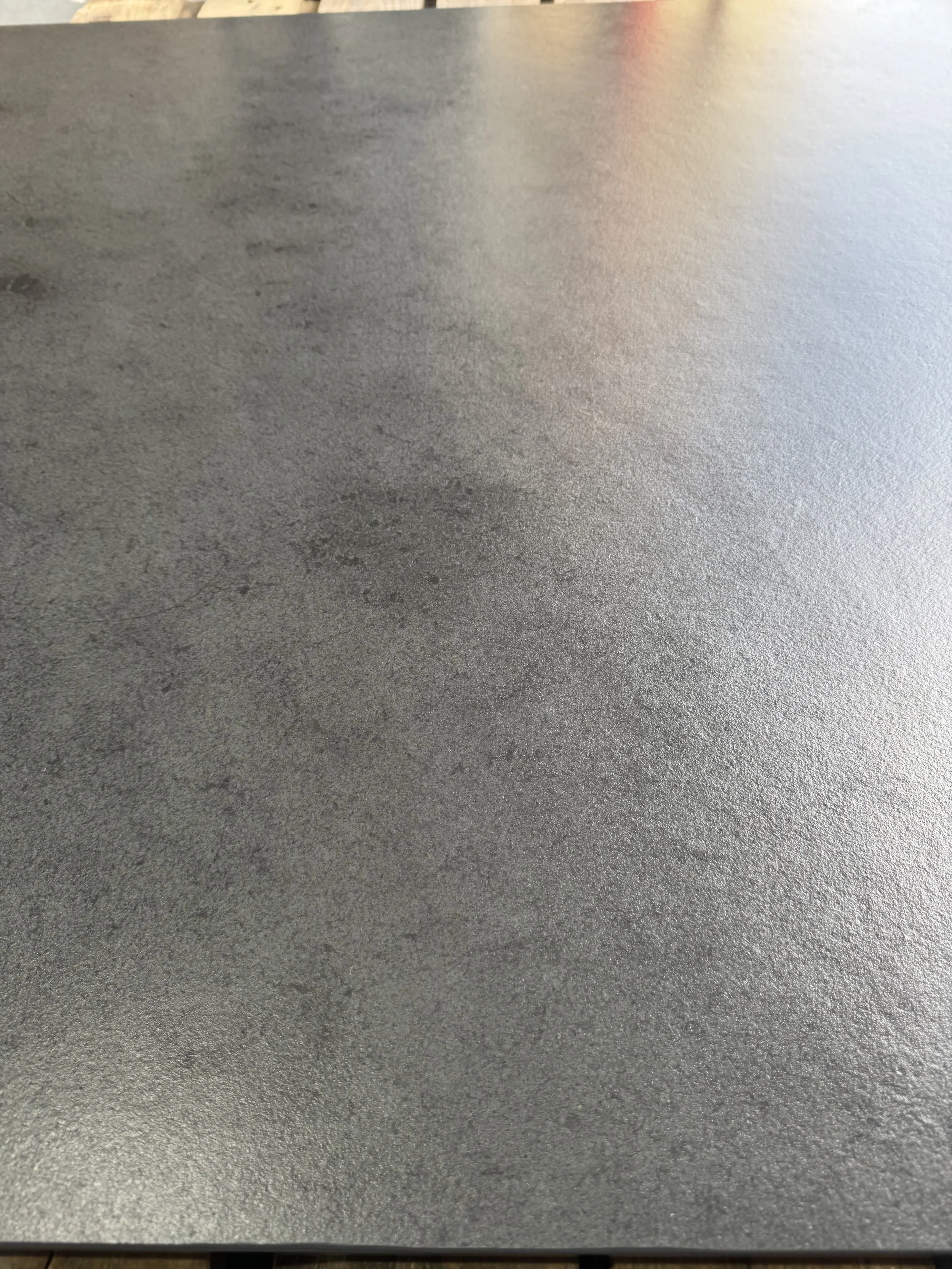 Close-up image of a textured gray surface, possibly metal or concrete.