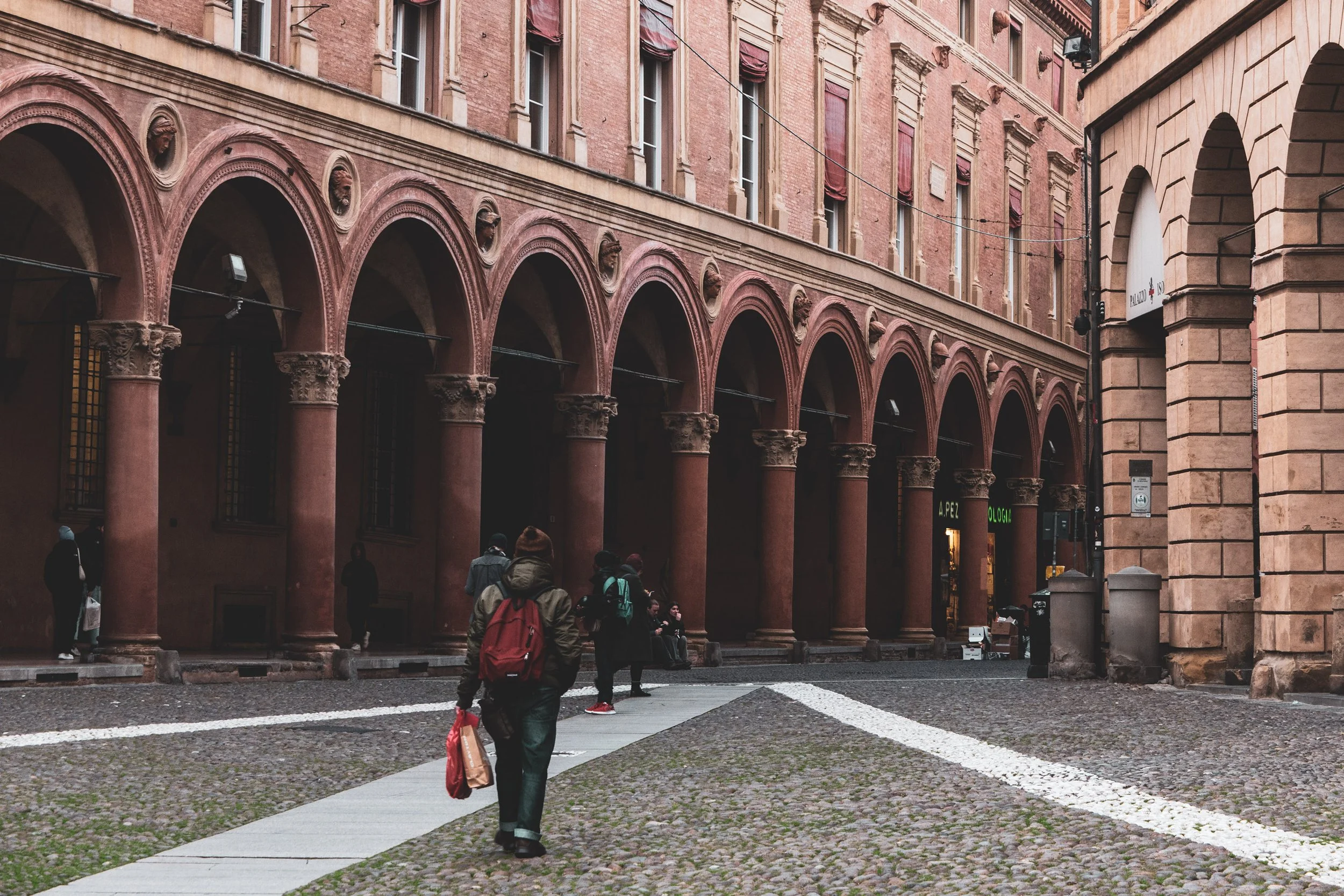 A group of people in a rustic square in Bologna, Italy taken on a Bologna Photography Tour