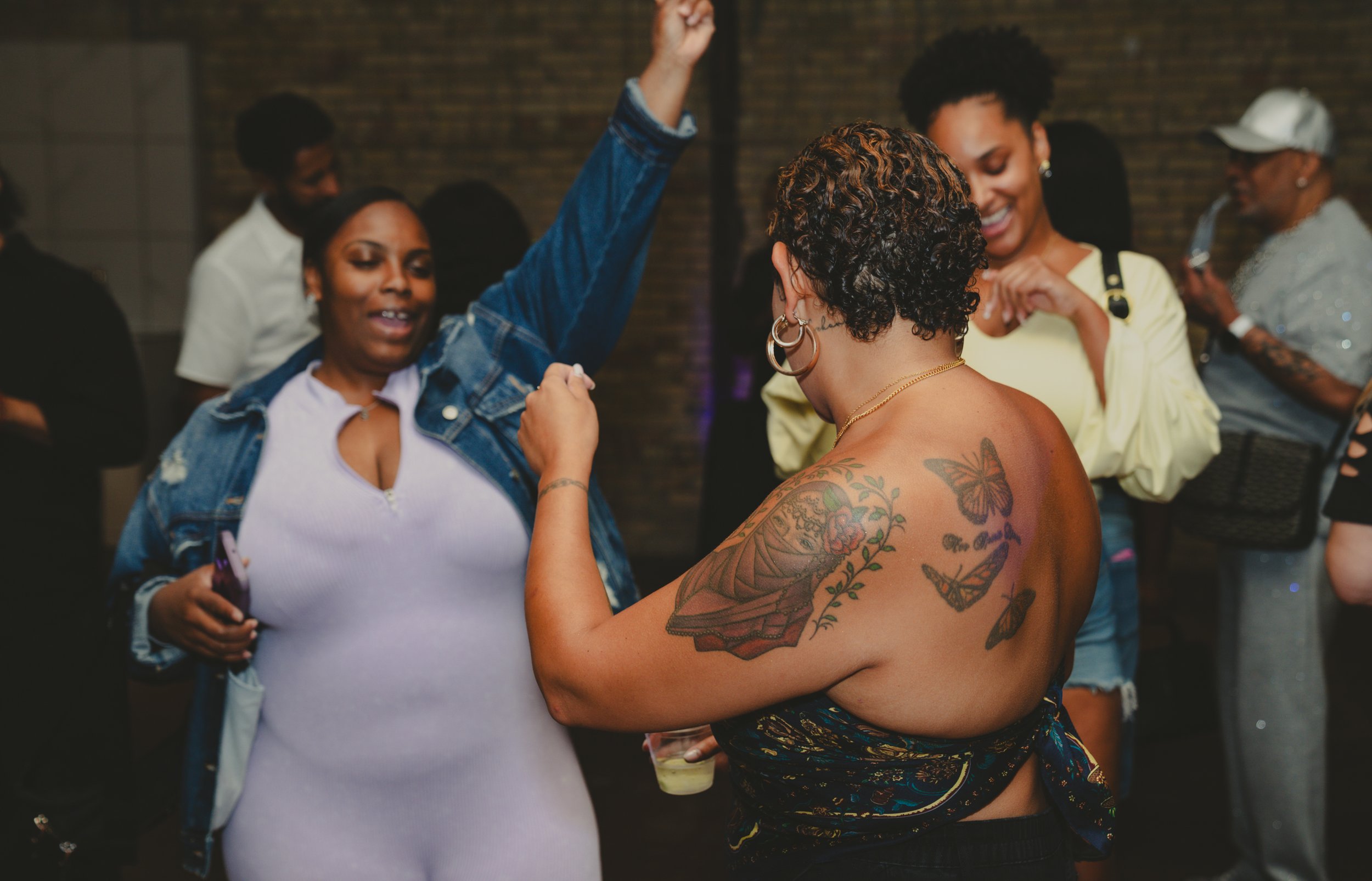 Group of people dancing and socializing at an indoor party or event.
