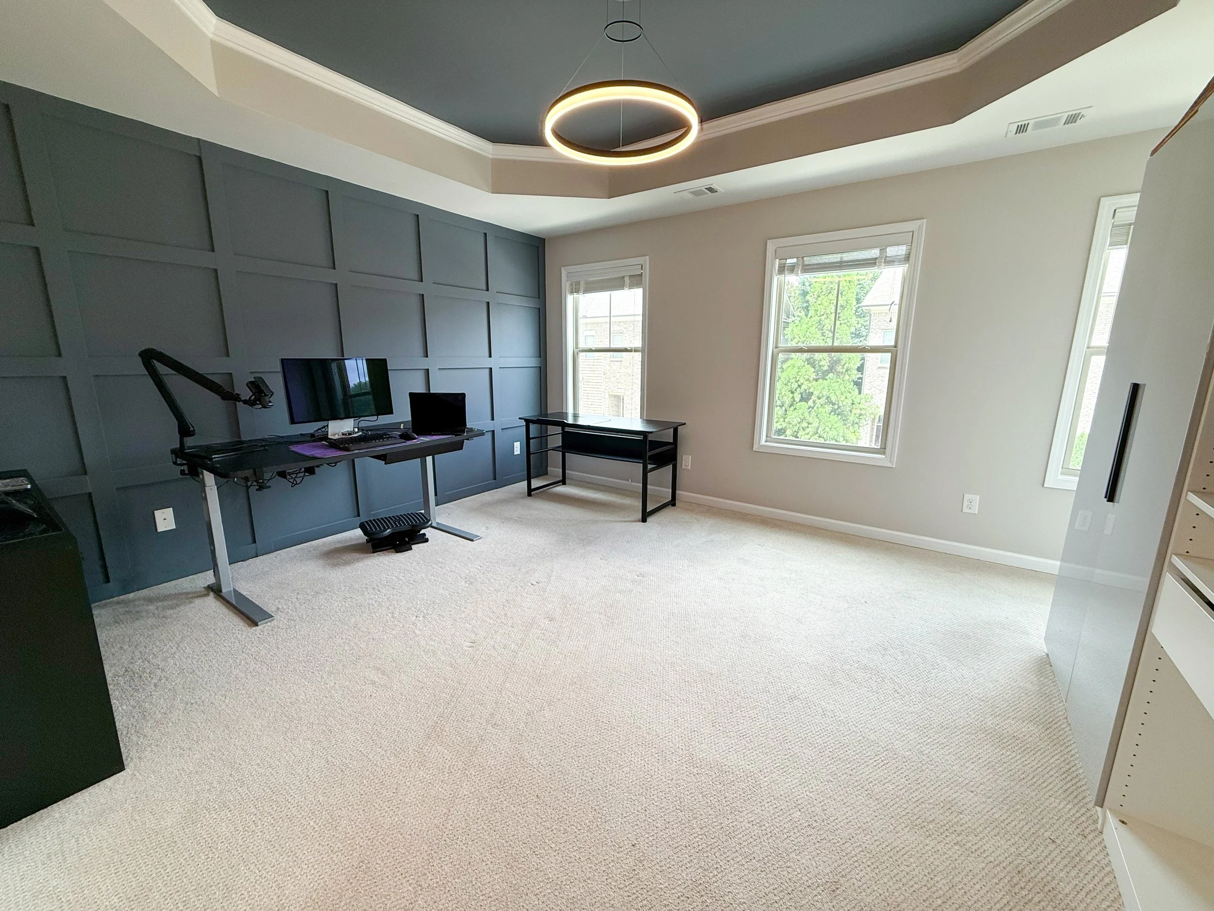 Spacious second bedroom with custom feature wall, tray ceiling, modern lighting, ensuite bath, and walk-in closet. Perfect as a bedroom or home office.