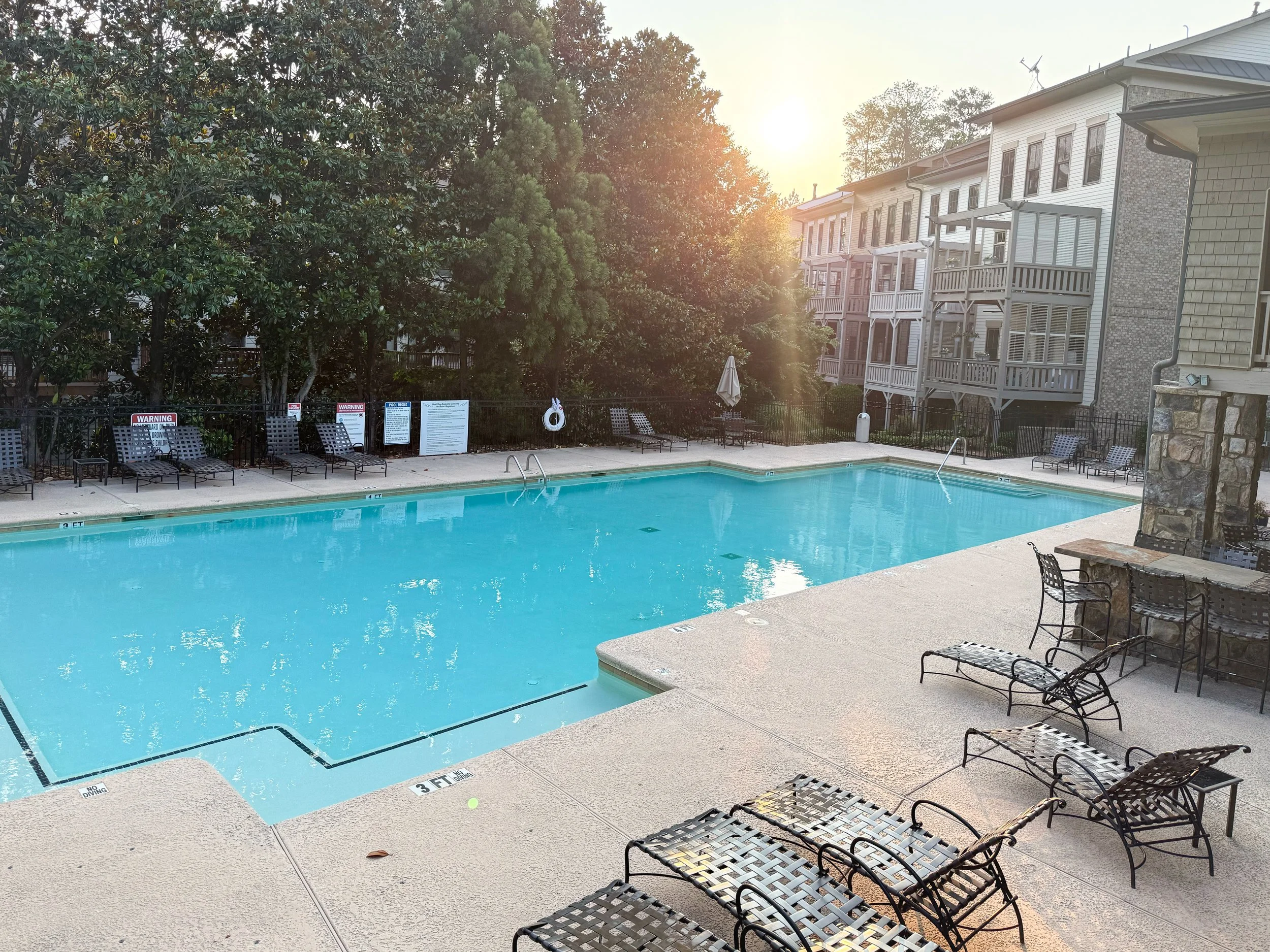 Spacious West Village pool with patio seating, grill, fireplace, and direct access to the clubhouse and gym.