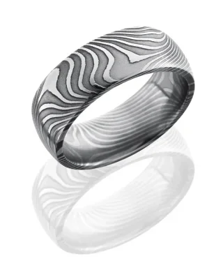 Close-up of a silver ring with intricate wave-like engravings.