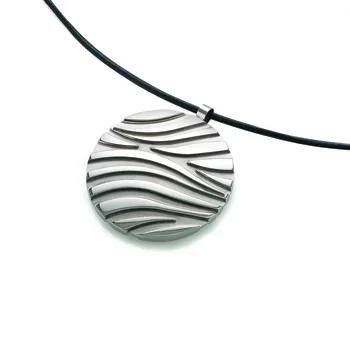 A round silver pendant with wavy black lines, hanging from a black cord.