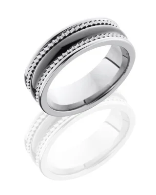 A silver ring with a black and white design, featuring textured and smooth patterns.