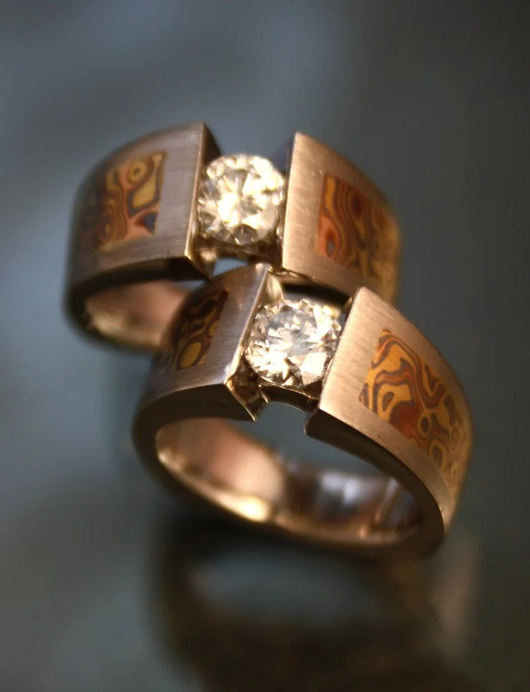 A gold ring with Mokume Gane pattern and a central square diamond.