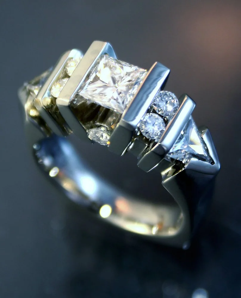 Silver ring with multiple rectangular and round diamonds.