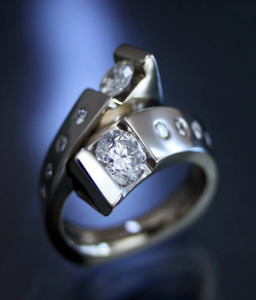 A silver ring with multiple diamonds set into it, on a dark background.