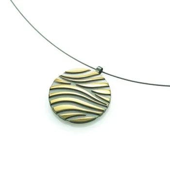 Circular pendant with black and yellow wave patterns, hanging from a thin wire