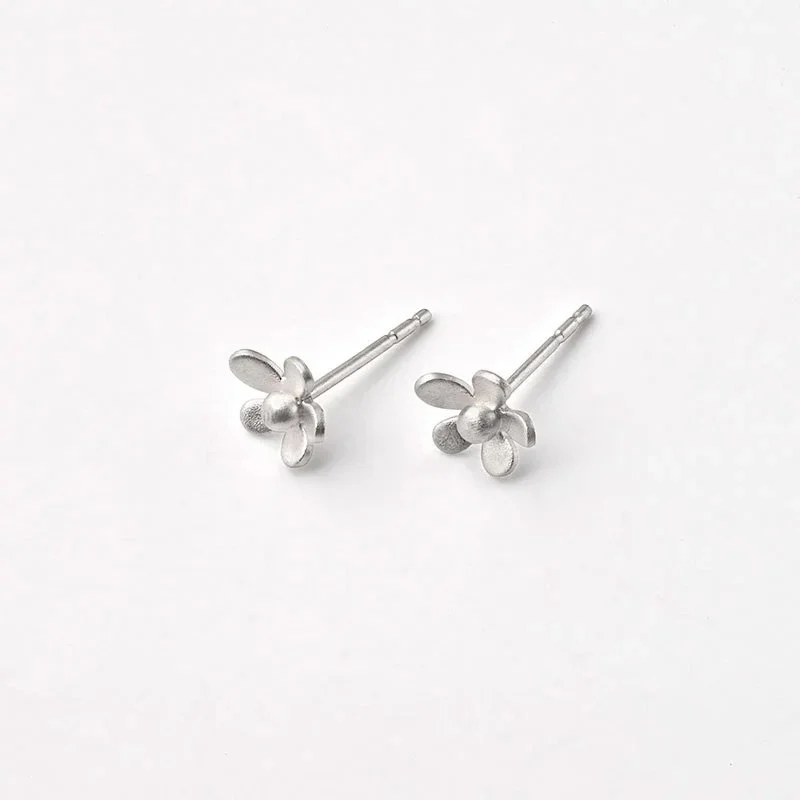 Silver flower-shaped stud earrings on a white background.