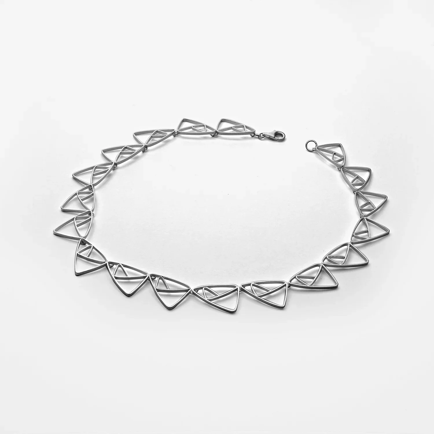 Silver geometric triangle necklace on a white background.