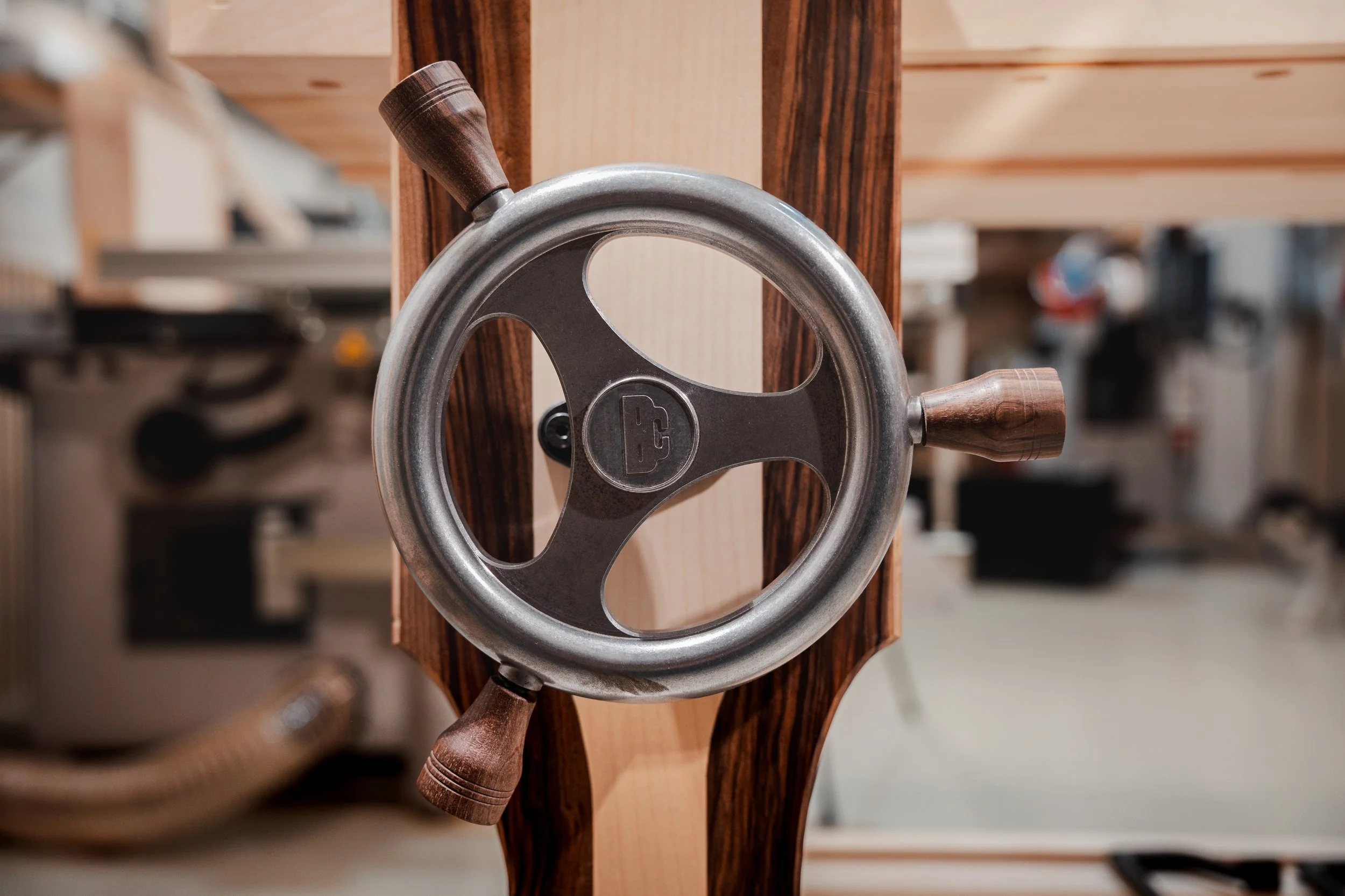 Holzarbeit mit einer Metallhandkurbel, vermutlich in einer Werkstatt