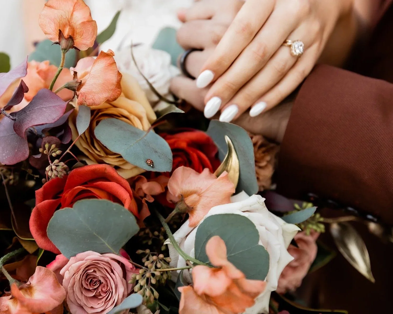 bride-and-groom-hands-close-up-rings-fall-florals