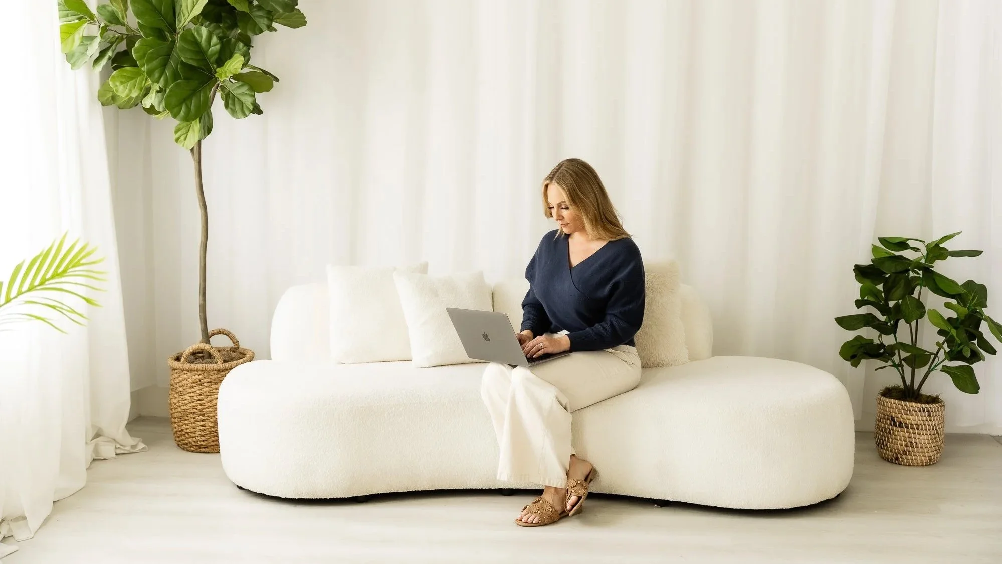 Branding client on couch with laptop in studio