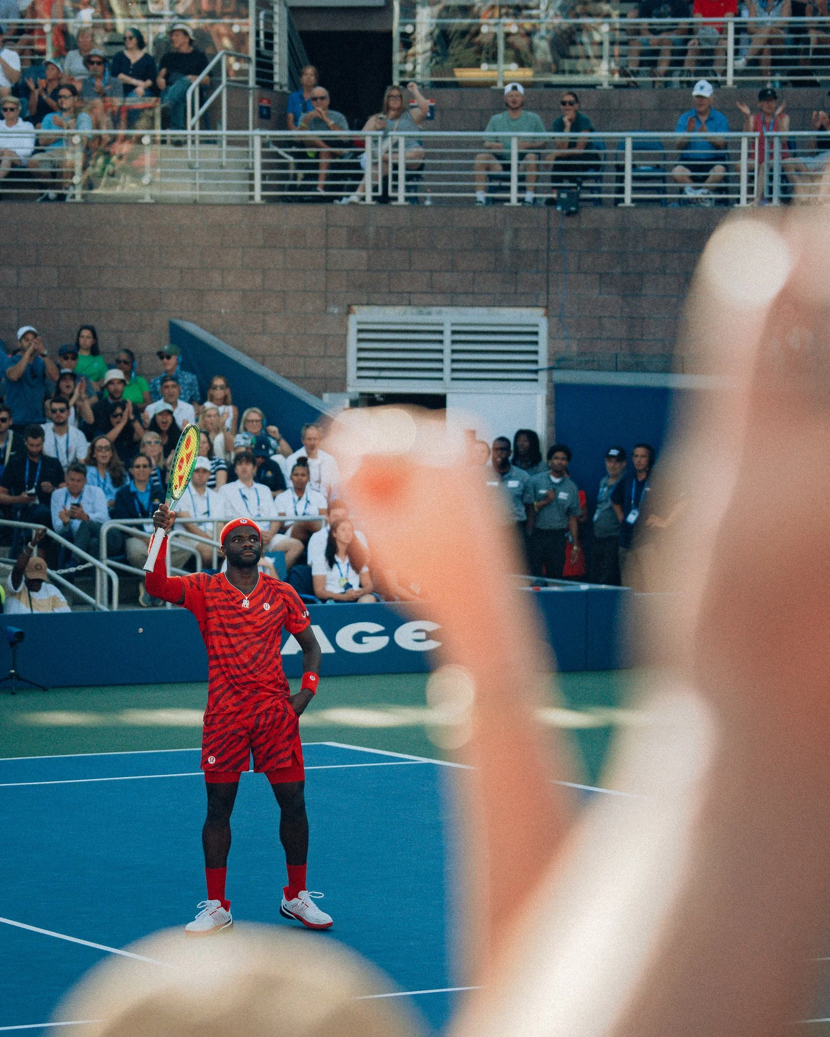 Professional tennis player, fist pumping to a large crowd as they do the same.