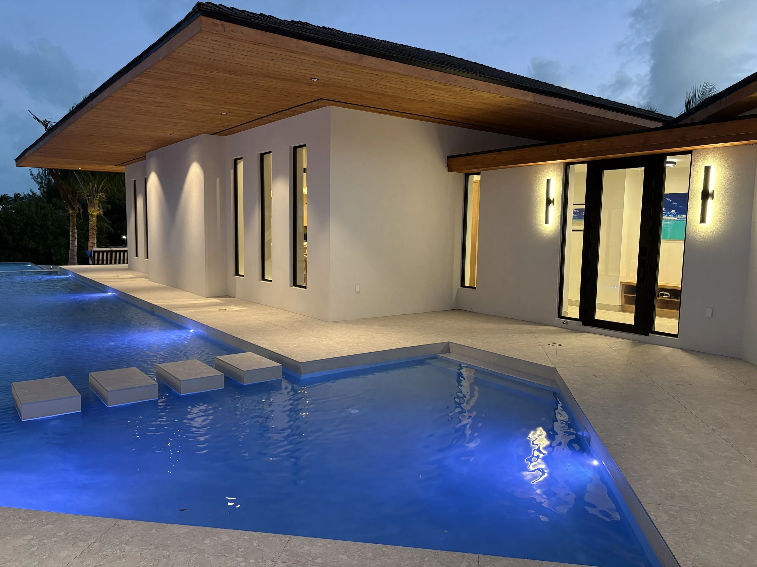 Modern house with a swimming pool and stepping stones at dusk