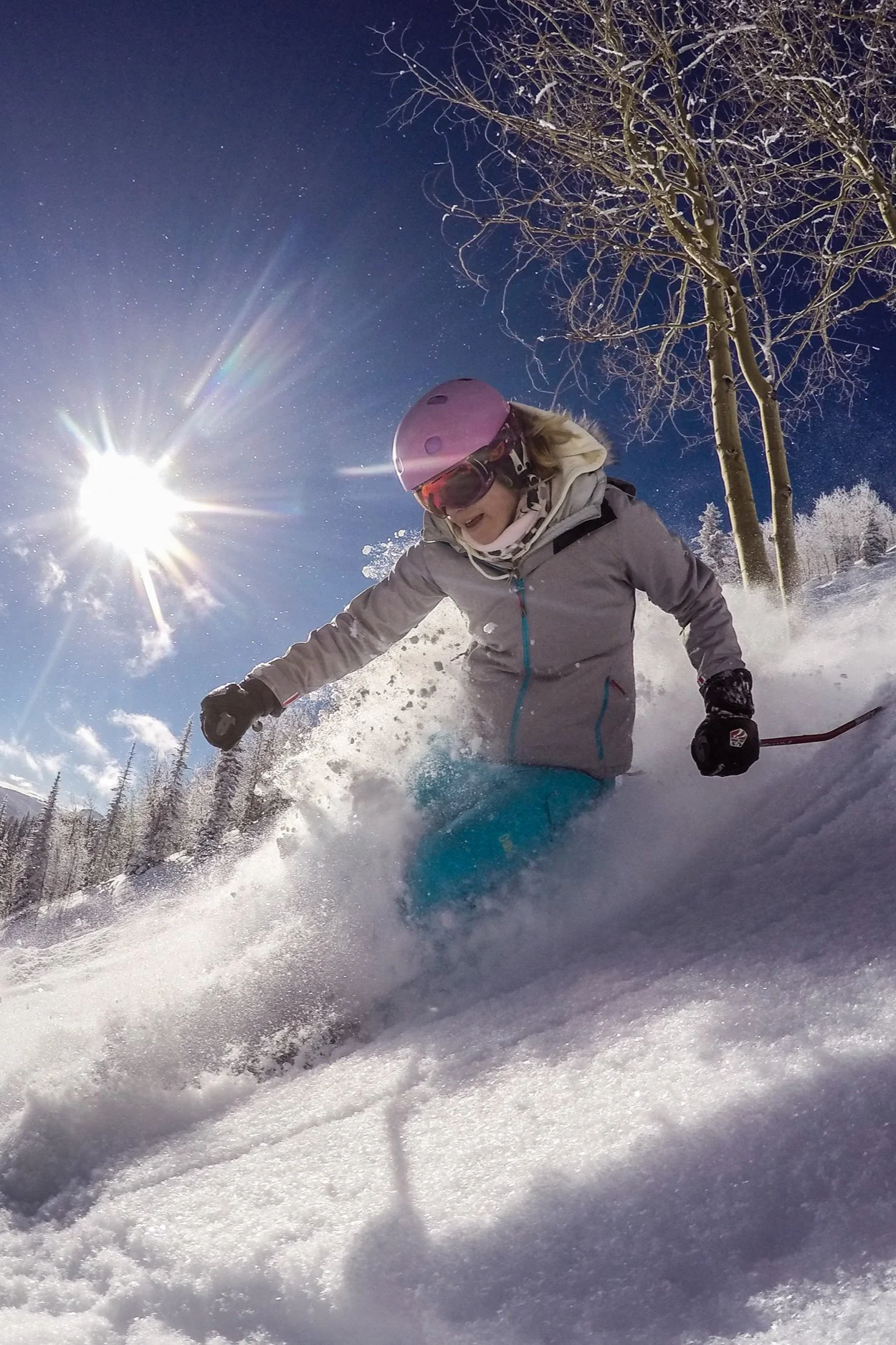 Amanda Wallman, founder of Alpine Edge Marketing, skiing through fresh powder on a sunny day.
