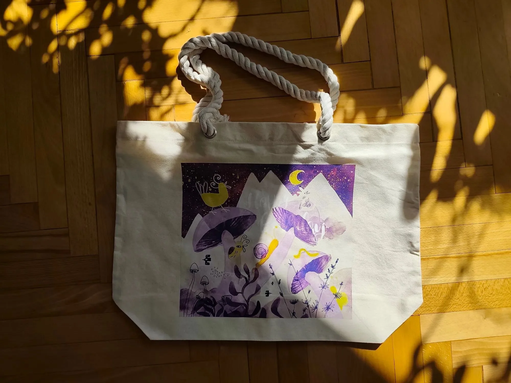 Beach bag featuring fragment of the “Tales of the Uncanny” illustration - sky, mountains, and mushrooms in cool violet and yellow tones.