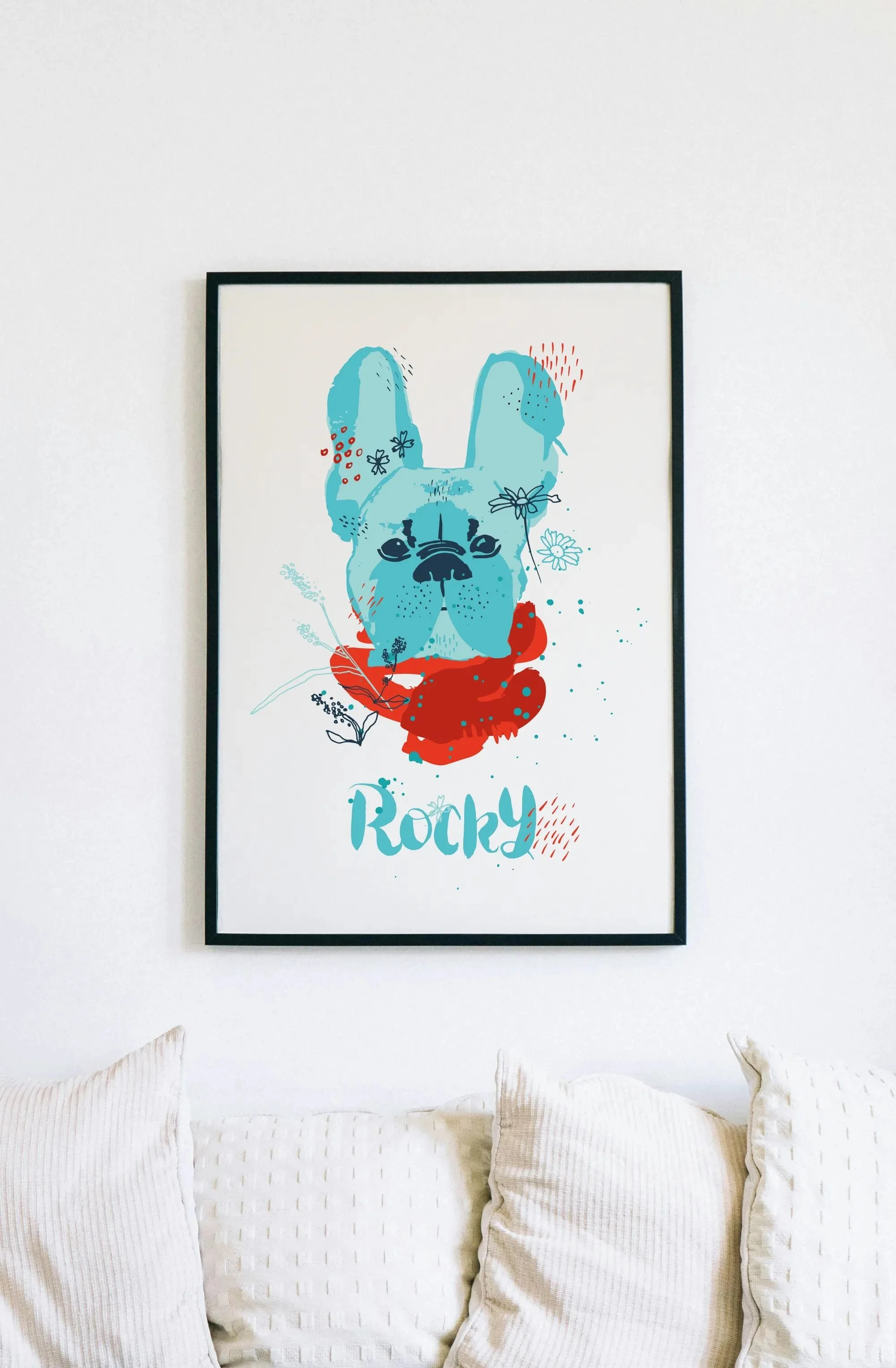 Framed watercolor portrait of a French bulldog hanging above white pillows on a sofa - warm interior with calm tones.