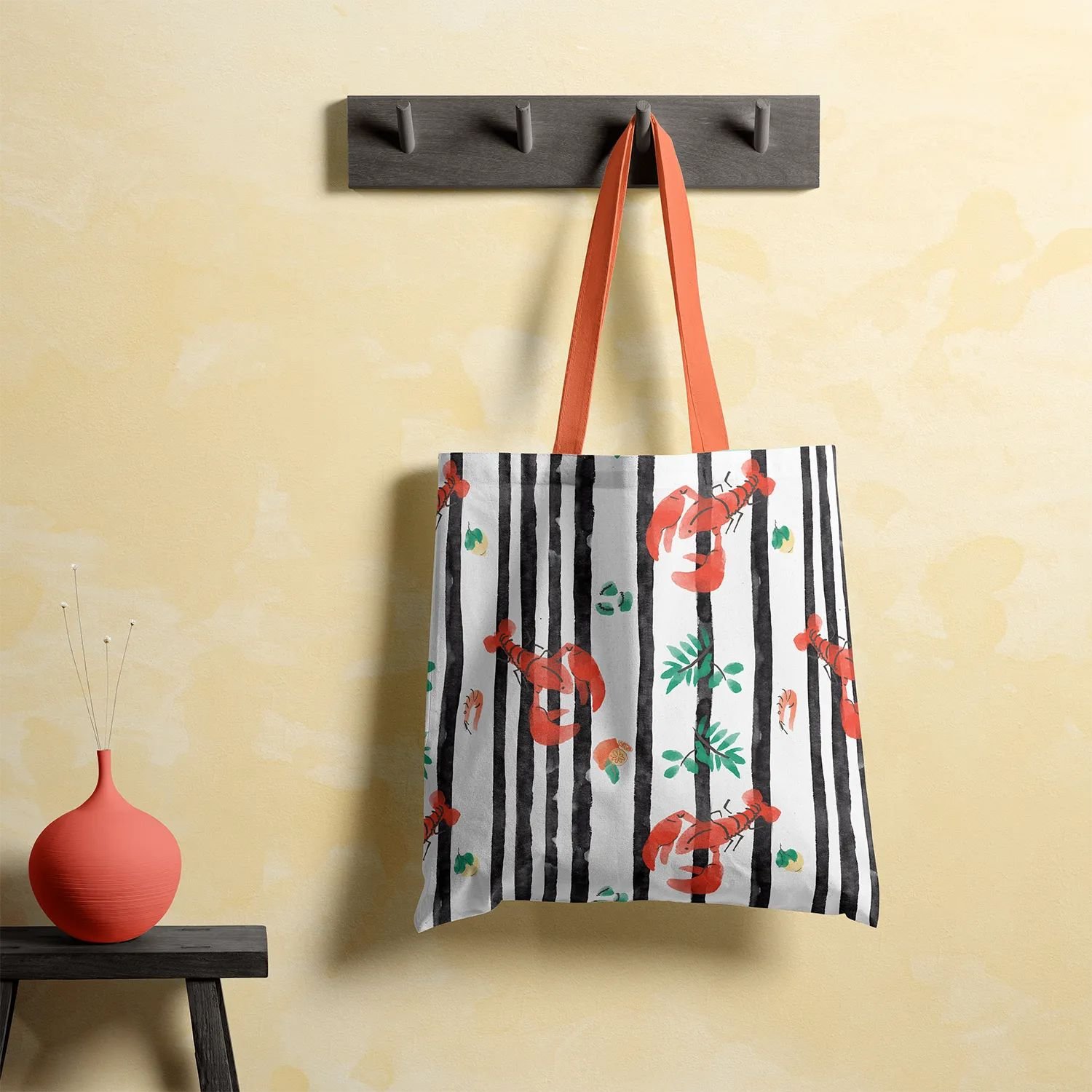 Tote bag printed with pattern from the Sicily collection — black stripes with red lobsters, lemons, seashells, and olive leaves.