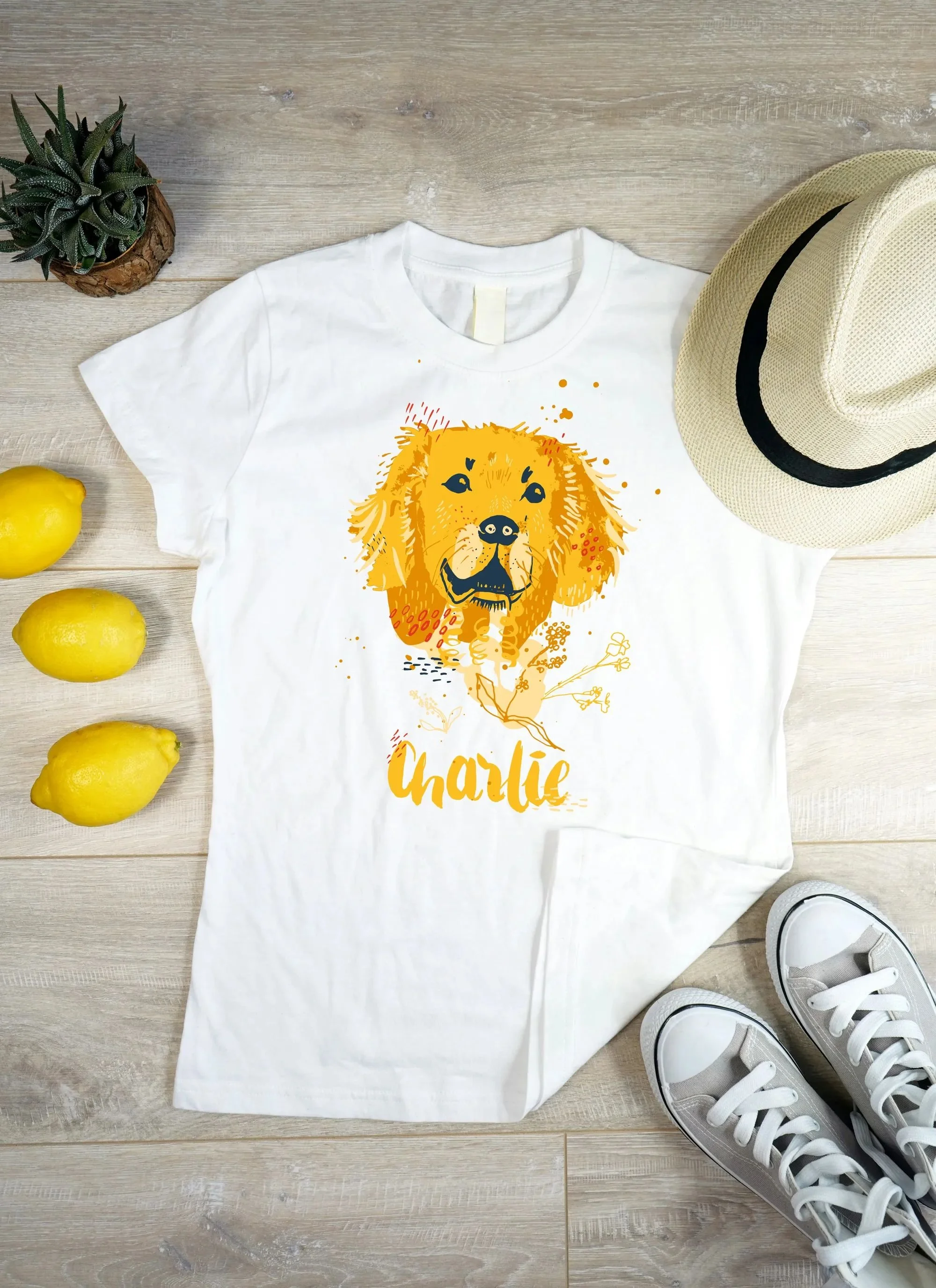 T-shirt with flat-style portrait of a golden retriever in warm yellow and red tones.