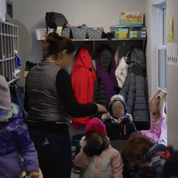 Une personne avec un sac à dos devant un bâtiment avec une fenêtre et un panneau indiquant "l'Œil. Ressource communautaire en santé mentale".