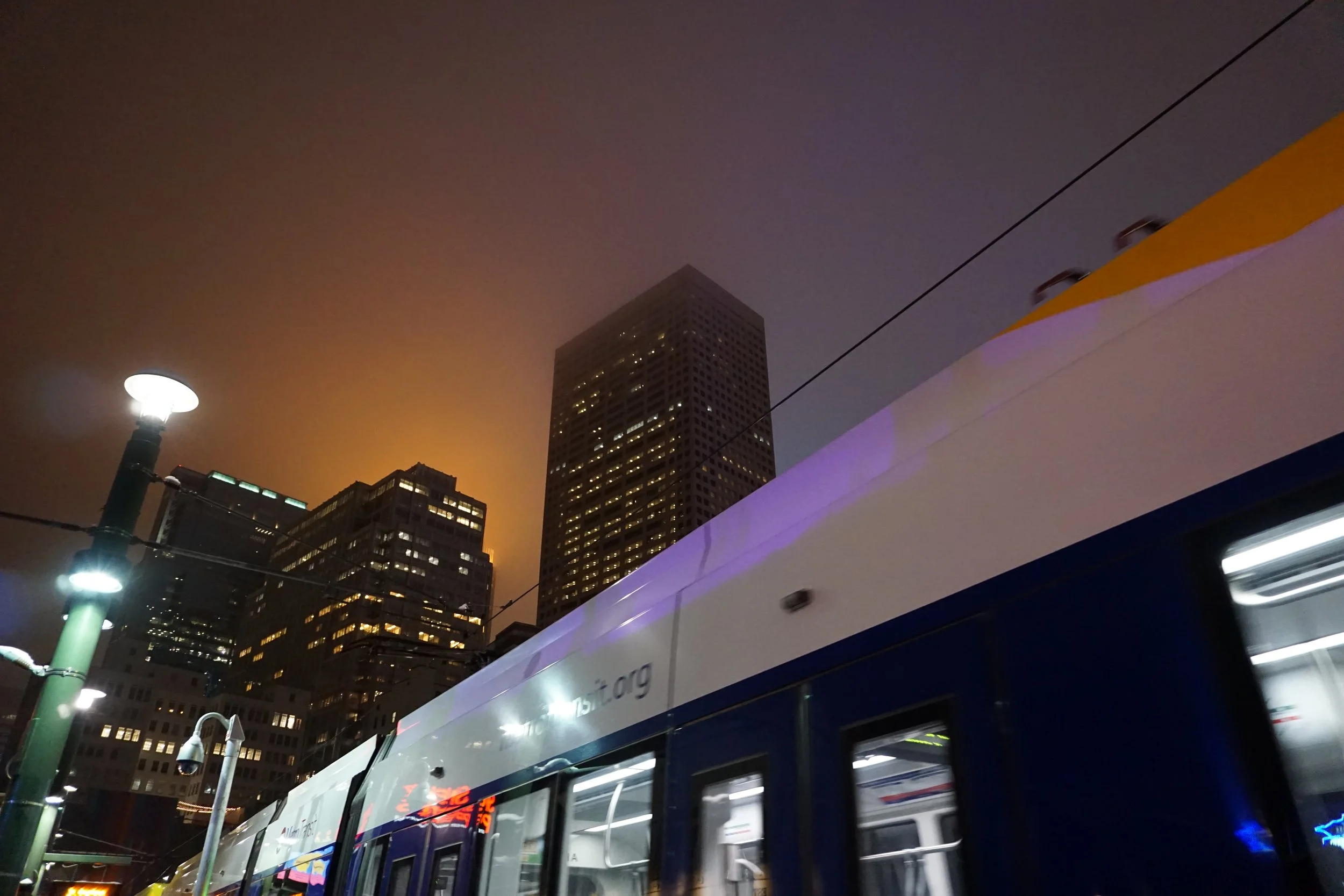 photo of a light rail car with the Minneapolis skyline behind it