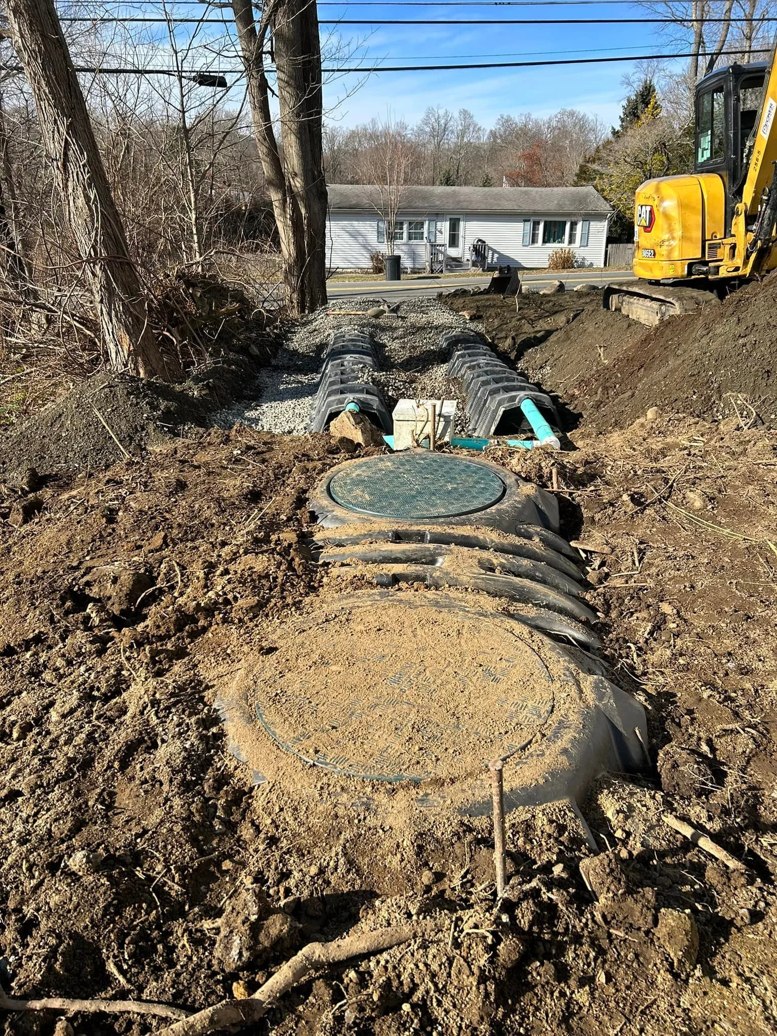 Underground septic tank installation and residential house in the distance.