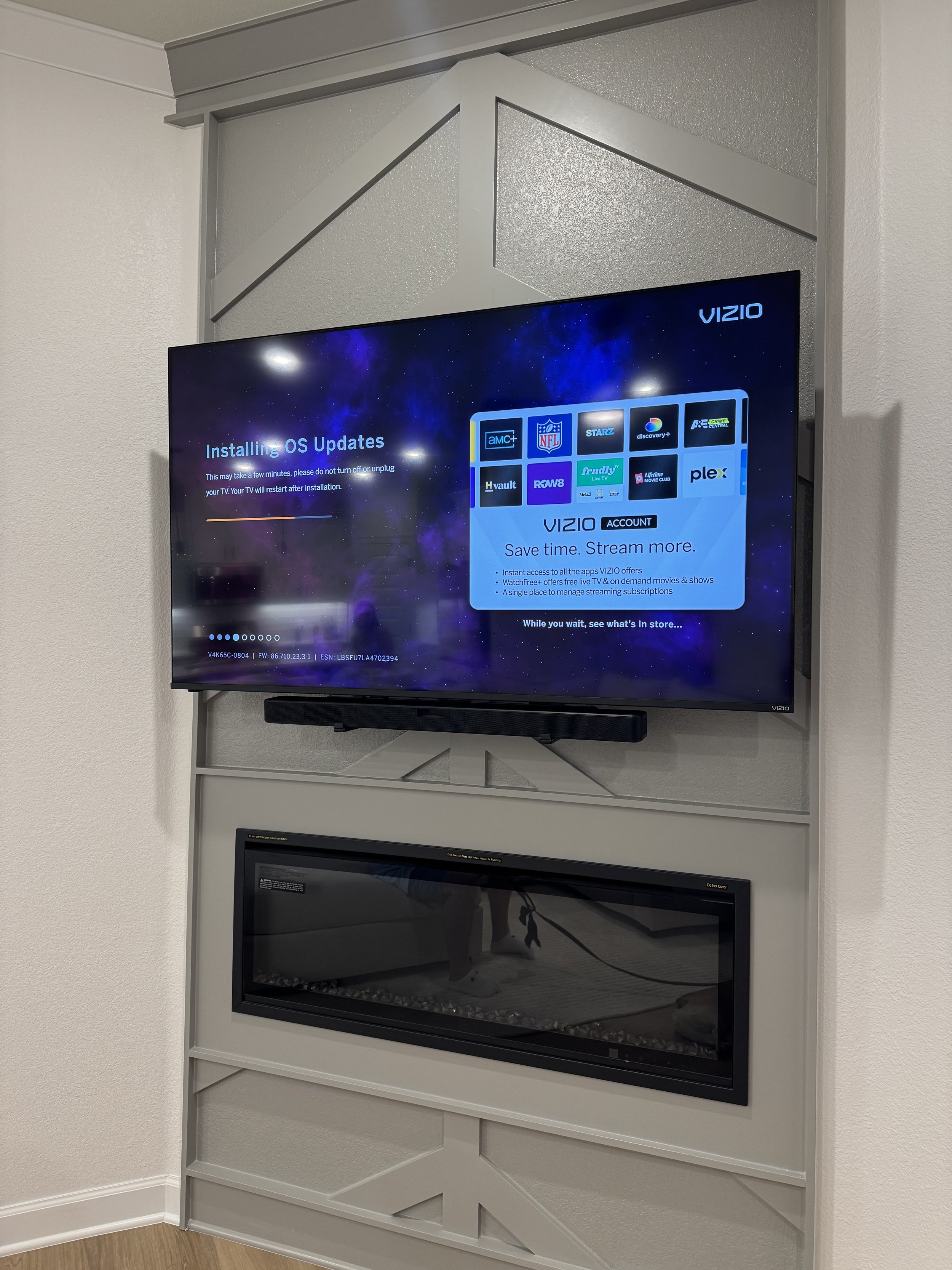 TV screen displaying a message about installing OS updates in a living room with a fireplace underneath.