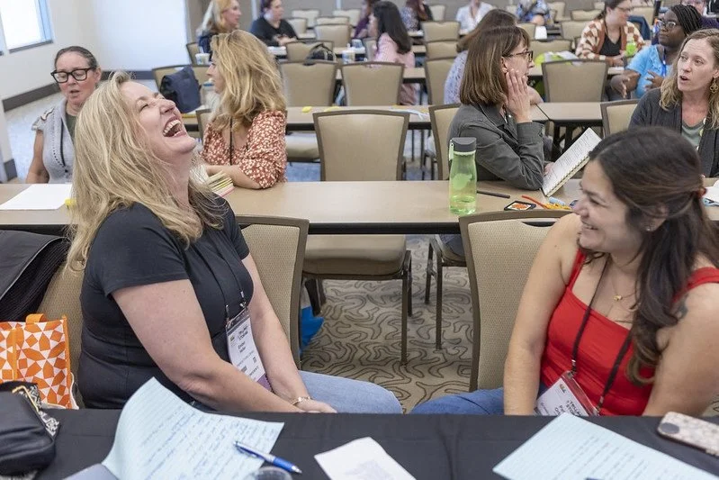 Two attendees having a laugh during a program at the 2025 CLA conference.