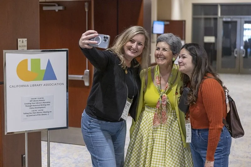 Cindy Mediavilla having selfie taken with two audience members at the 2025 CLA conference.