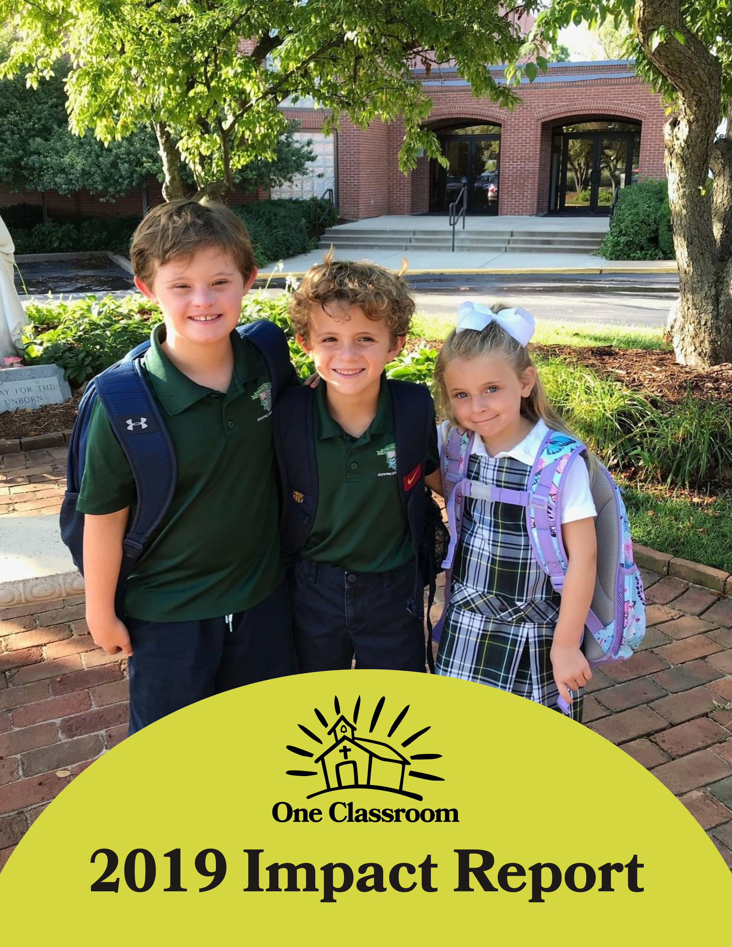Three school children standing outdoors in front of a building with step access, all carrying backpacks and smiling for the camera. In the foreground, there's a yellow banner with a black house icon and text that reads "One Classroom 2019 Impact Report".