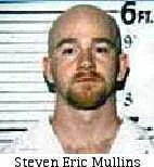 Mugshot of a bald man with a beard, standing against a height measurement chart.