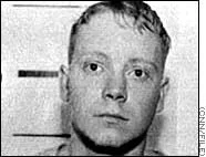 Black and white portrait of a young man with short hair, looking slightly to the side.