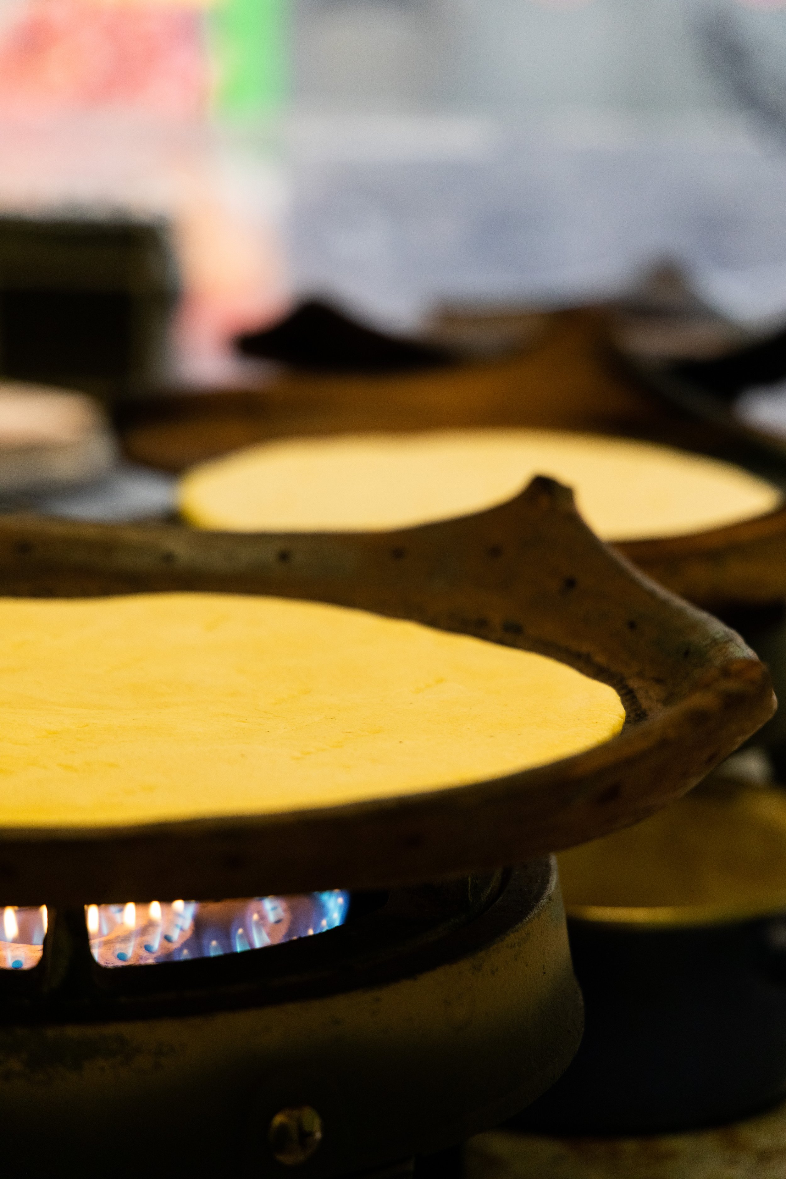 Close-up of flat, circular Algerian kesra bread cooking on a gas stove in Marseille.