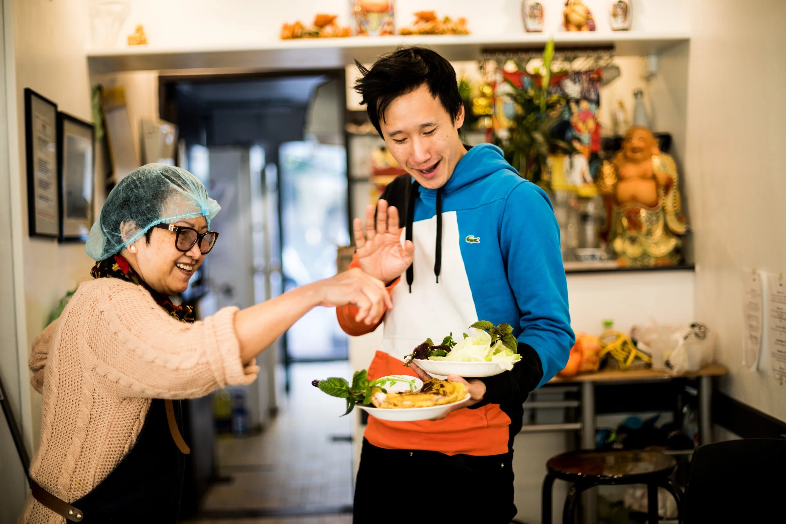 Vietnamese Female chef and her son sharing a joyful moment in a kitchen in Marseille.
