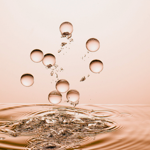 Water droplets splashing above a rippling water surface.