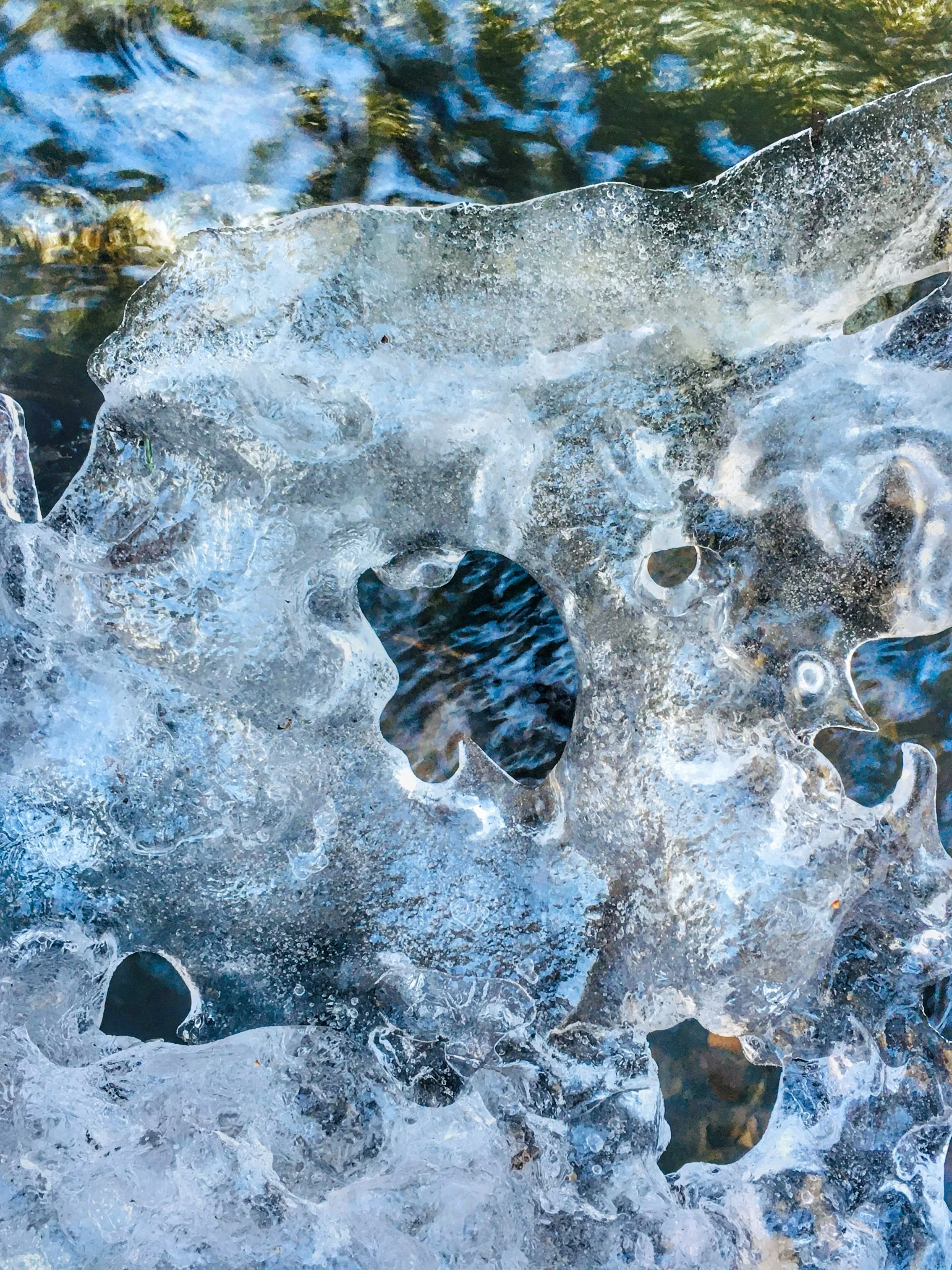 SPRING THAW - North Adams, Massachusetts (March 21, 2021) - As winter turns into spring, the ice-imprisoned Notch Brook is transforming on the shoulder of Mt. Greylock. The retreating ice is translucent, and windows on the water are melting into view