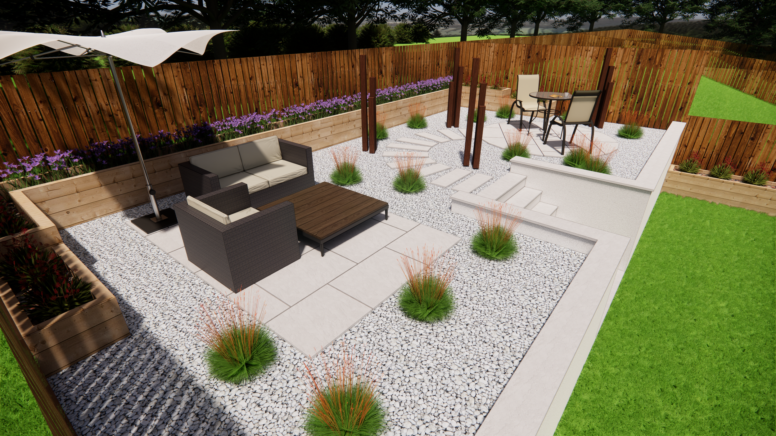 A landscaped backyard patio with a wooden fence, gravel ground cover, and a variety of outdoor furniture including a lounge dining table with chairs, a corner sofa, and a sun umbrella. There are planters with purple flowers and ornamental grasses, a small set of stairs, and a lush green lawn.