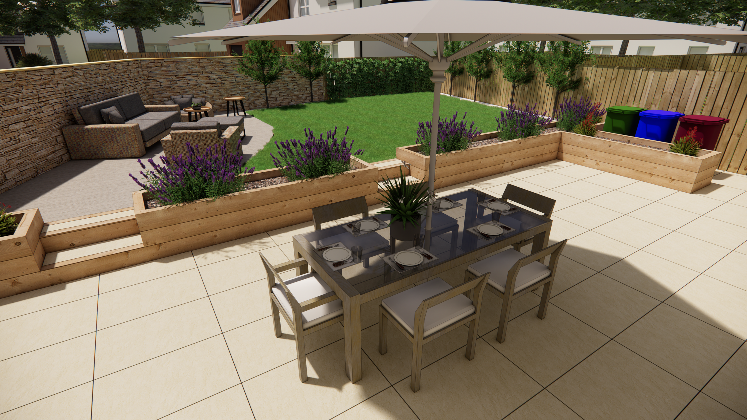 A backyard patio with a dining table and six chairs under a large umbrella. The patio has beige tiles and flower beds with purple lavender, and a grassy area with outdoor seating and a stone wall in the background. Green, blue, and red trash bins are in a corner.