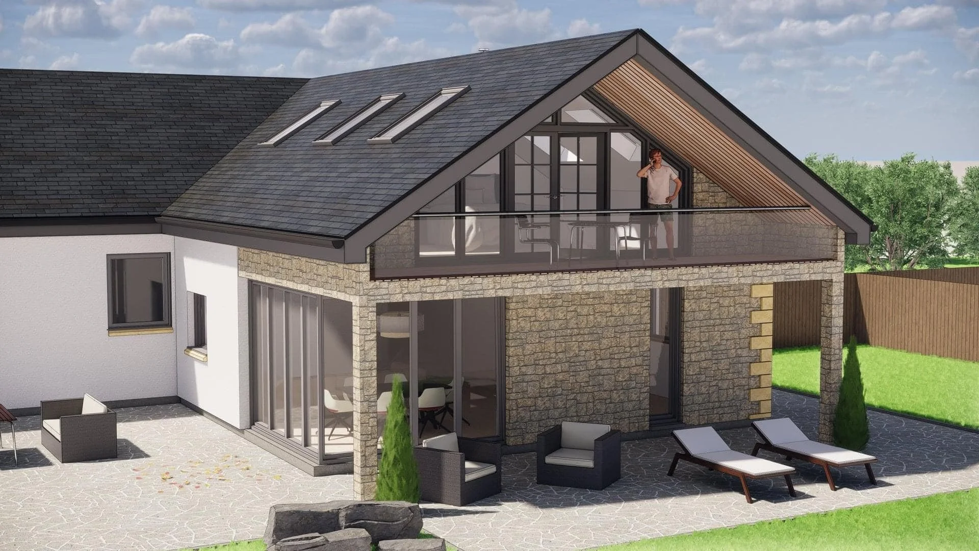 Modern two-story house with a stone and white exterior, large windows, a patio with outdoor seating, and a man on the upper balcony talking on the phone. The backyard is landscaped with green grass, trees, and a wooden fence.