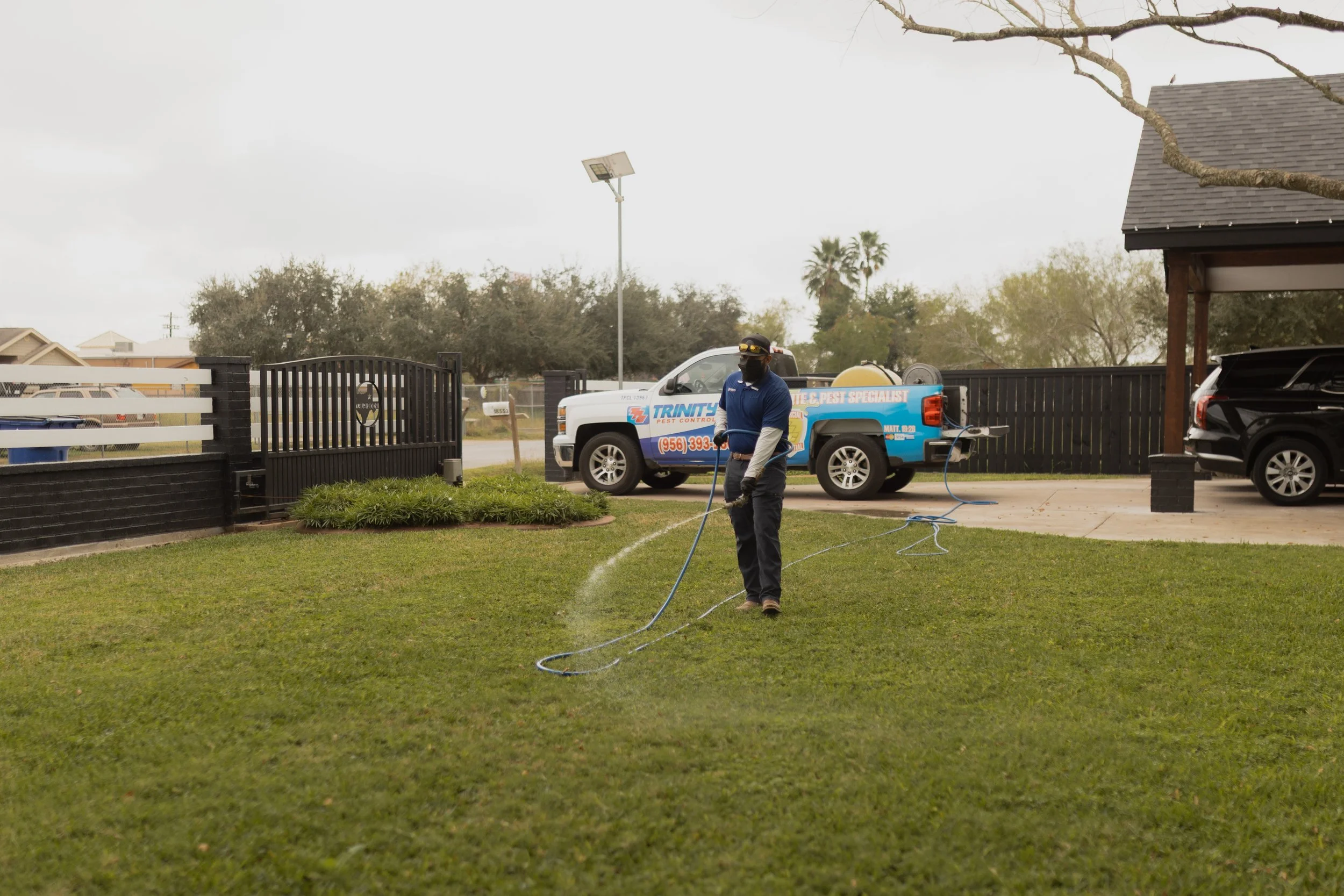 Trinity Pest Control Technician servicing yard
