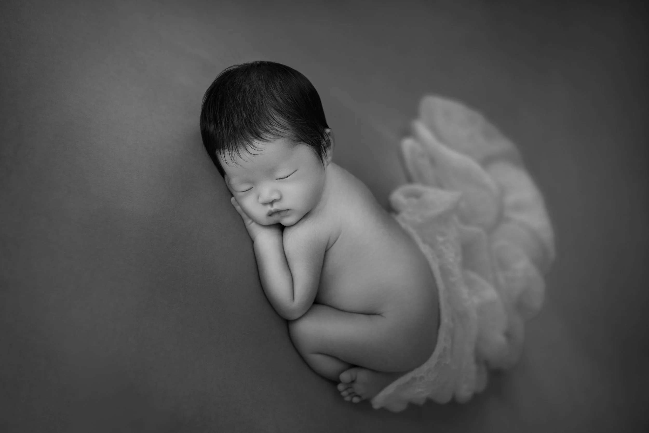 新生児の赤ちゃんが眠っている黒白の写真