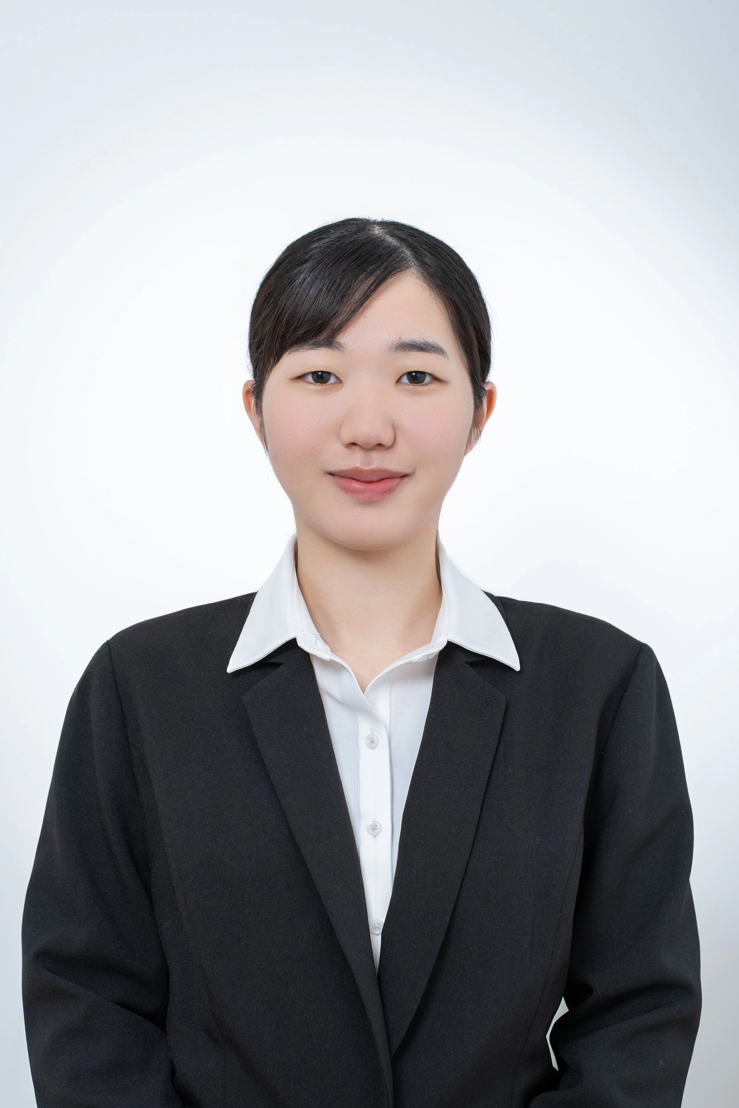 白い背景に黒いスーツを着た女性のポートレート画像