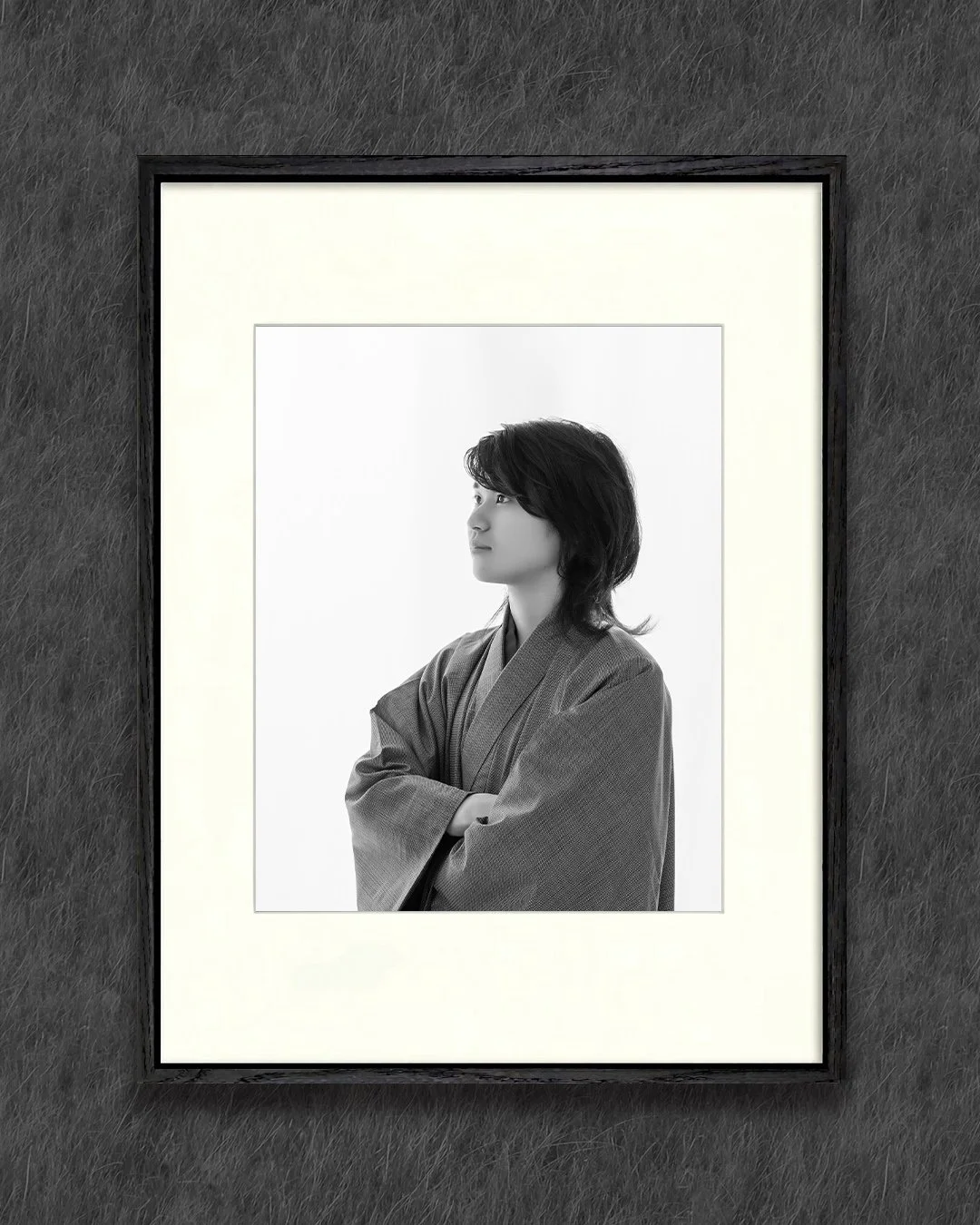 黒い木製フレームに額装された、着物（袴）姿の男性のモノクロポートレート。腕を組み、遠くを見つめる凛とした立ち姿。