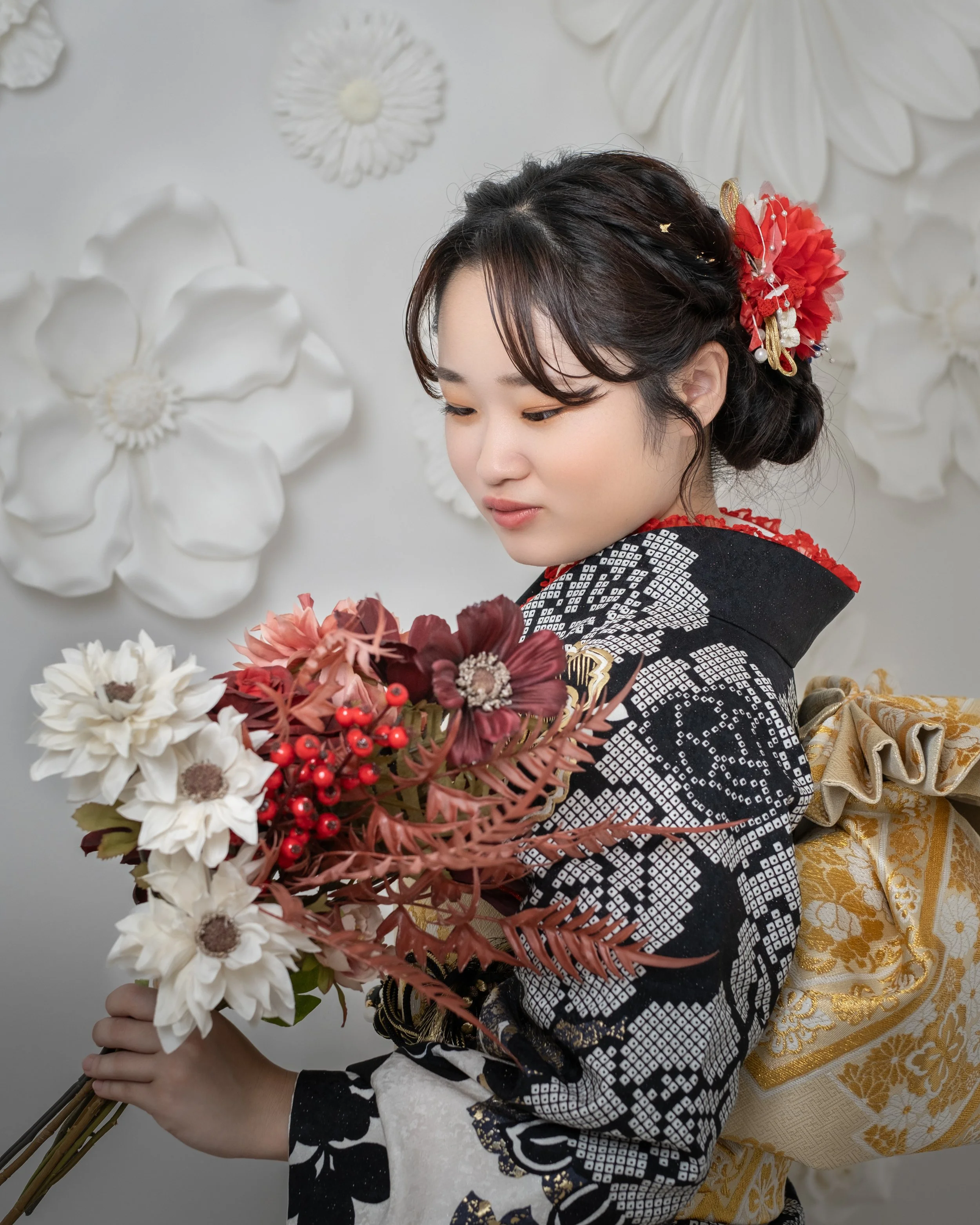 和服を着た女性が花束を持っている