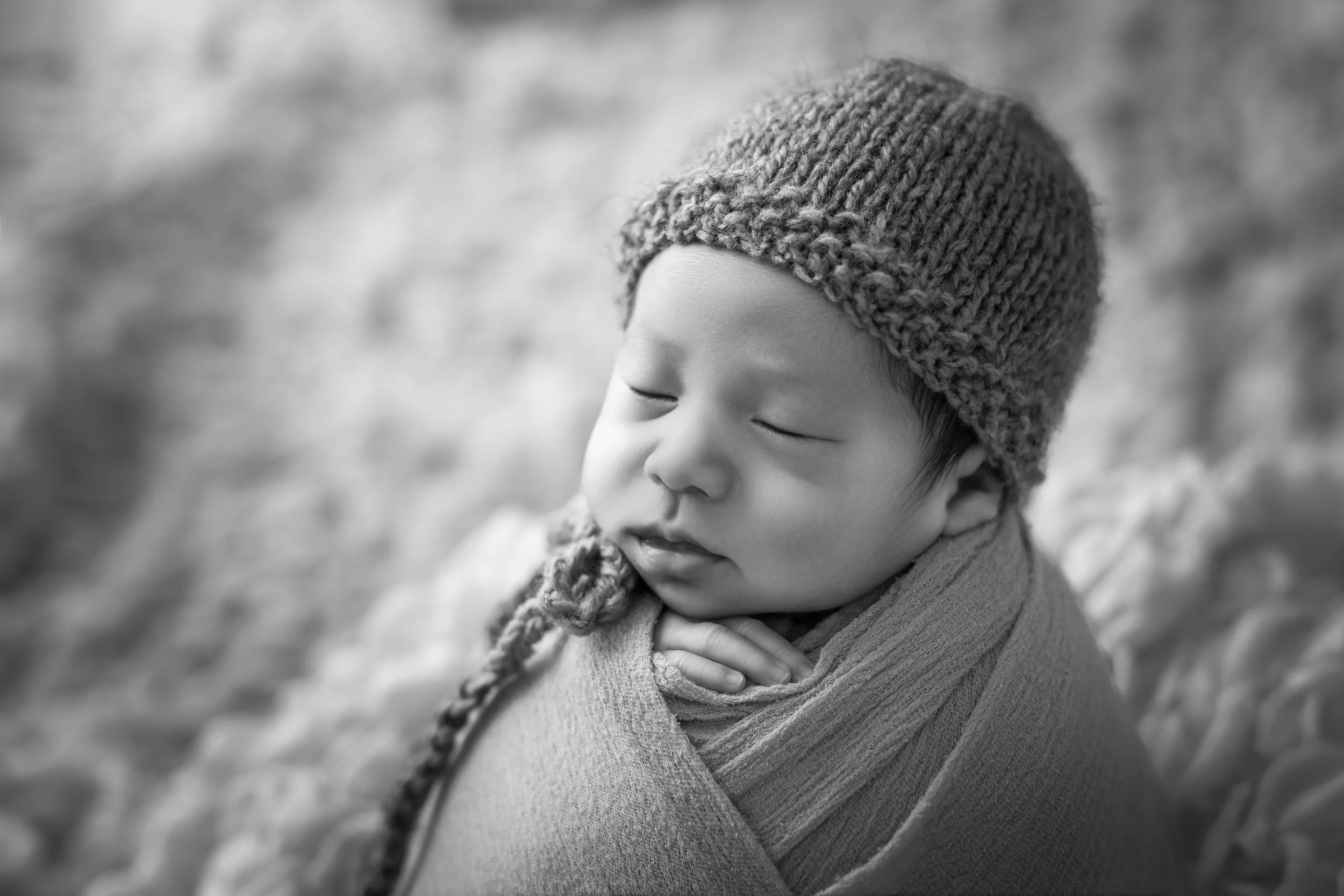 毛糸の帽子をかぶった赤ちゃんの黒と白の写真