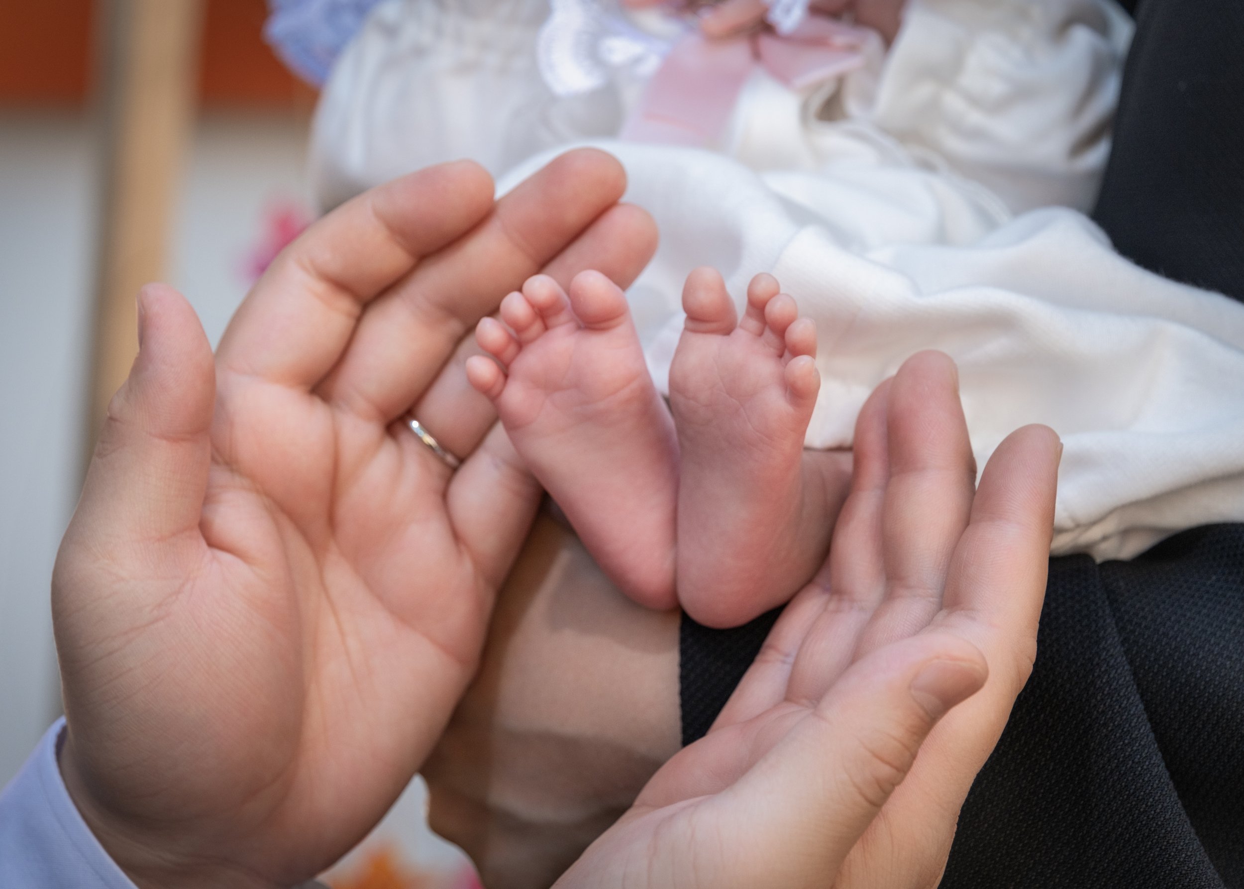 赤ちゃんの小さな足を親の手が優しく包み込むシーン