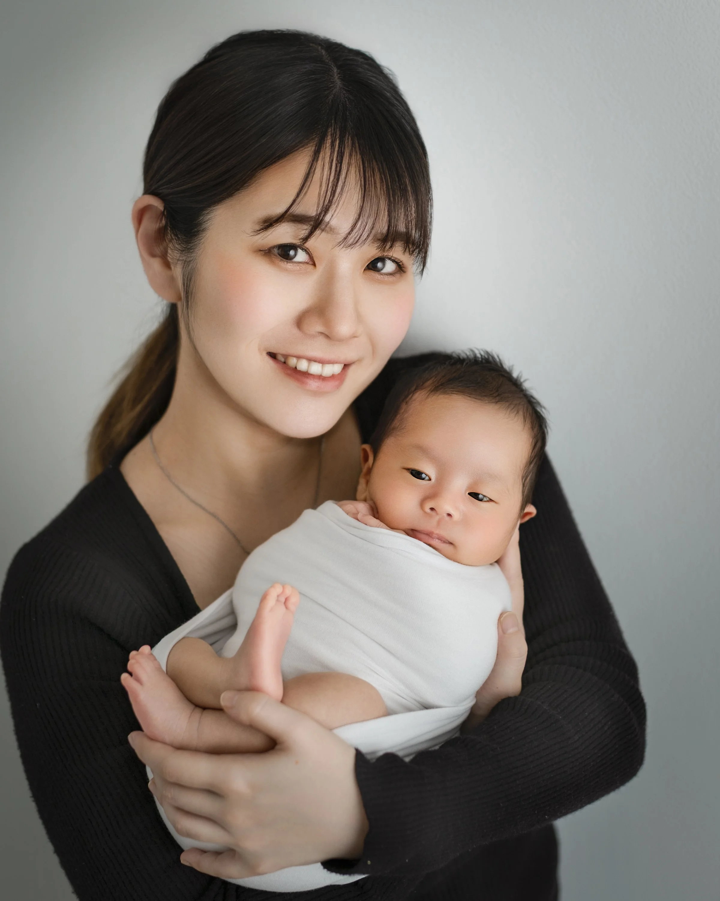 笑顔のママが赤ちゃん抱き締めている写真