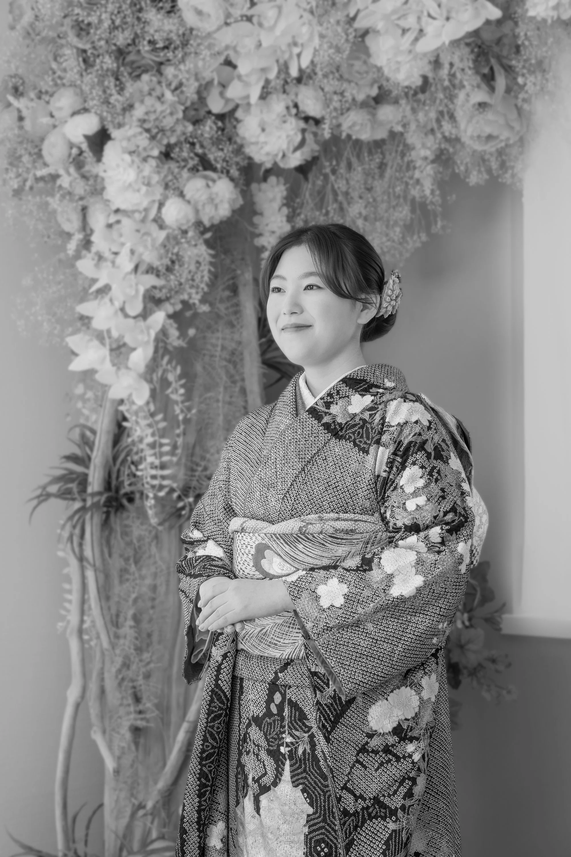 着物を着た女性が花の装飾の前に立っている日本の伝統的なスタイルの写真