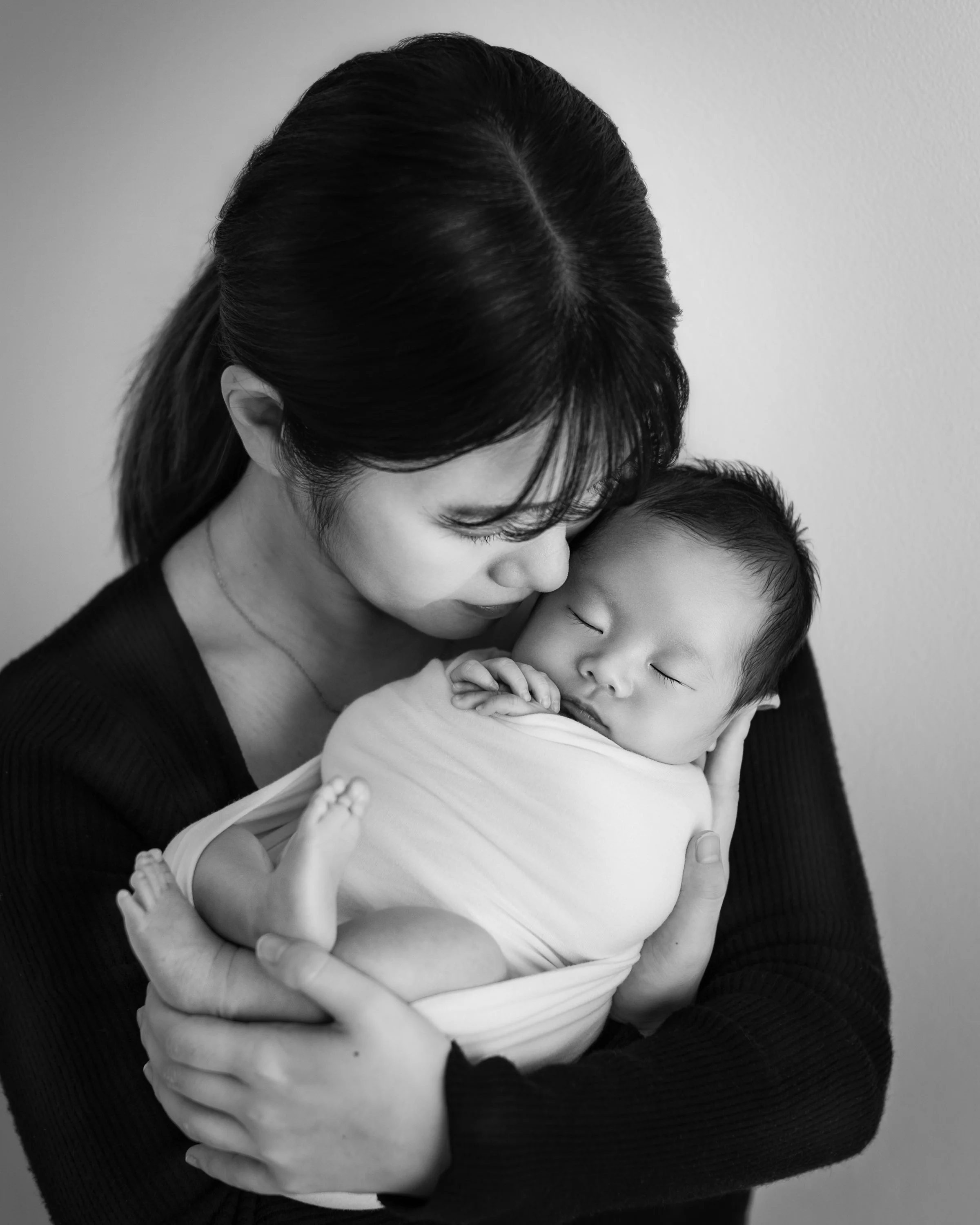 母親が赤ちゃんを抱きしめている白黒写真